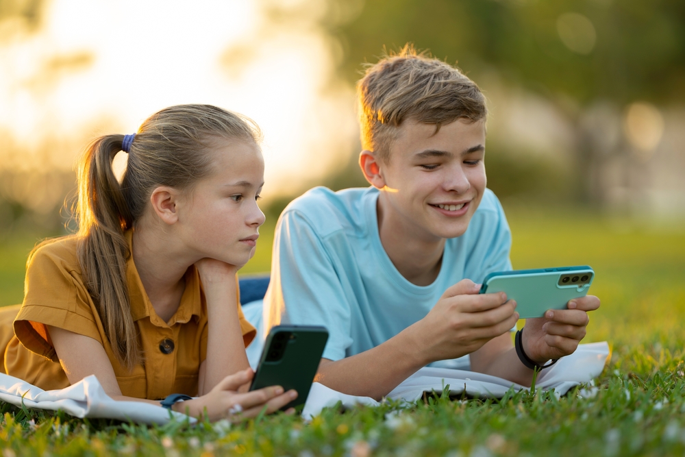 Teens without parents on phones in a field